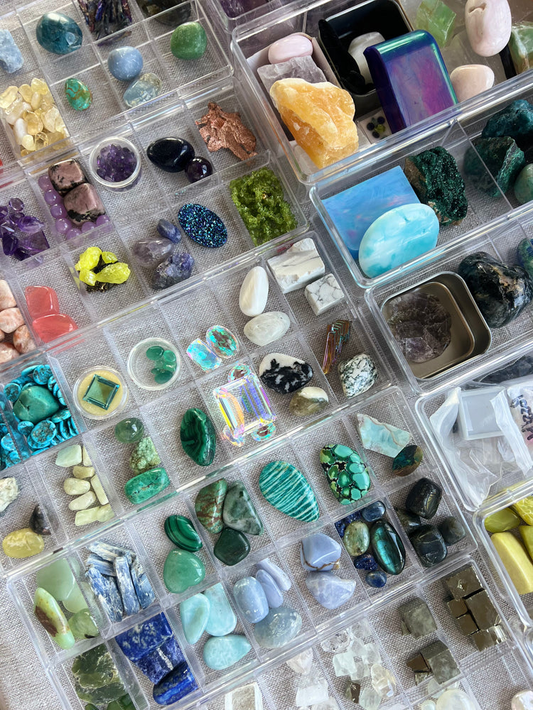 Trays of crystals and minerals from Brit's collection, sorted by color