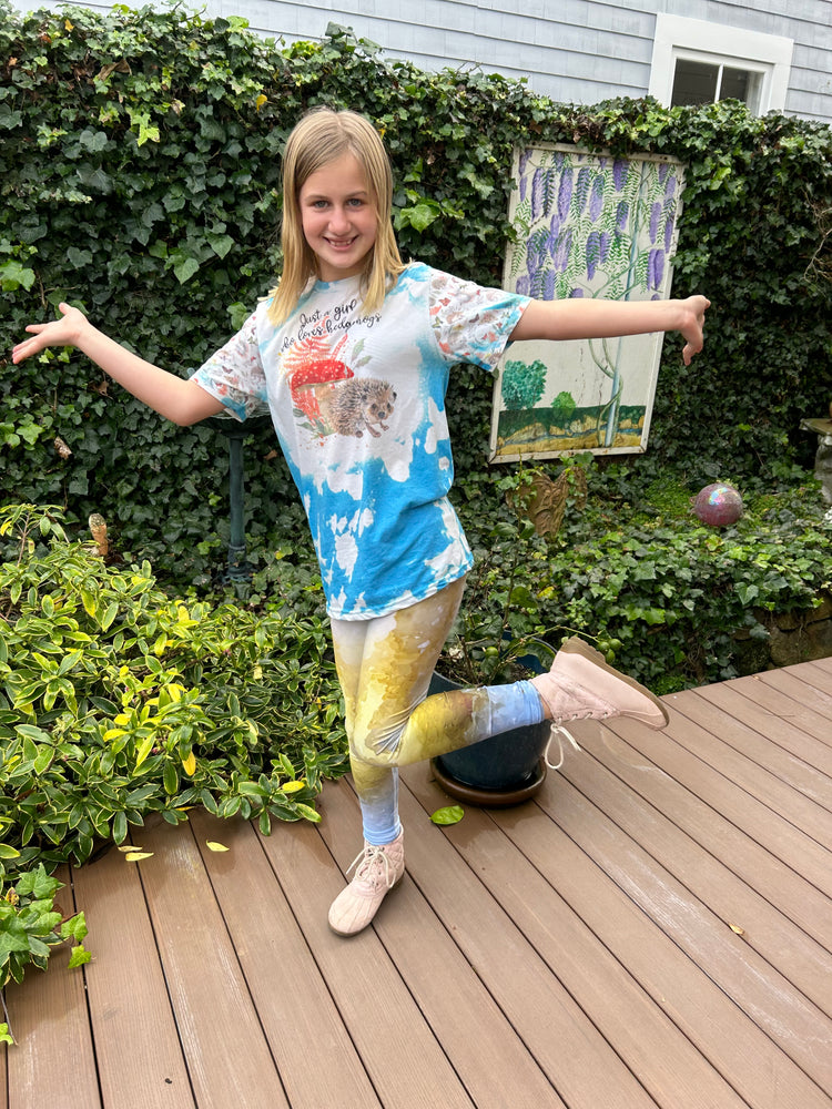 Smiling girl posing on a garden deck in yellow and blue printed leggings